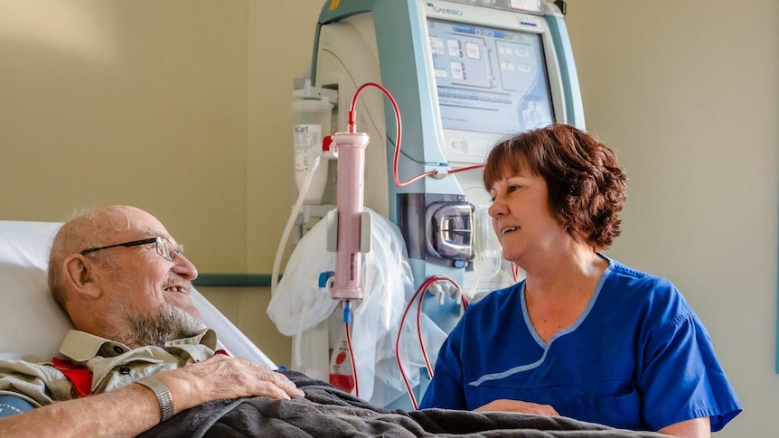 A nurse cares for an elderly hospital patient
