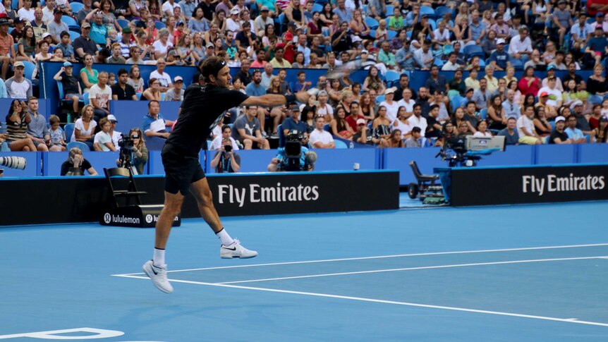 Roger Federer jumps as he smacks the ball in a warm up the day before Hopman Cup in Perth.