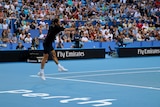 Roger Federer jumps as he smacks the ball in a warm up the day before Hopman Cup in Perth.