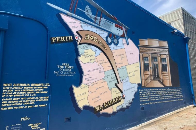 A street art mural depicting a map of WA and a colonial building.