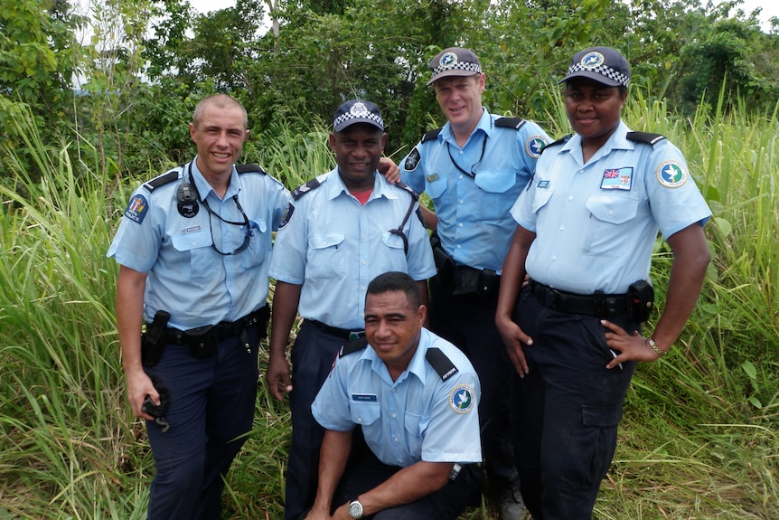A group of five police personnel, two Australian and three locals, in the Solomon Islands.