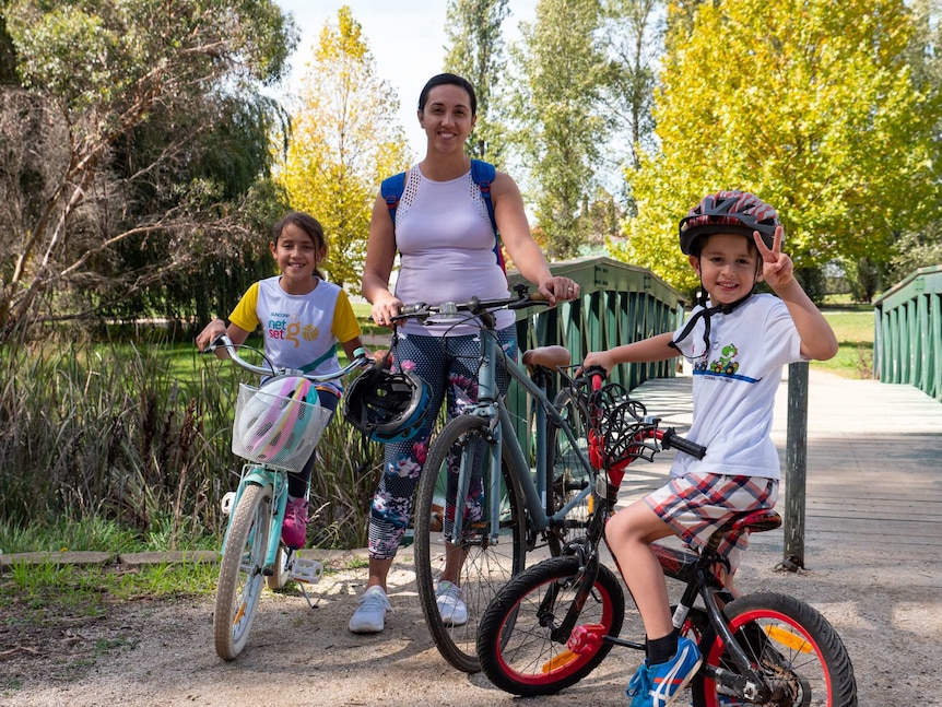 Woman with two children with bicycles.