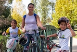 Woman with two children with bicycles.