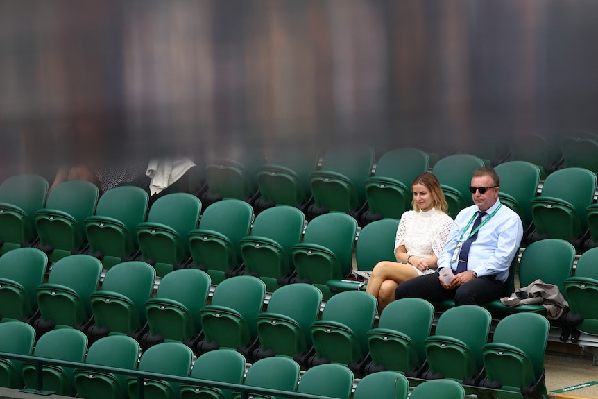 Two people sitting among four rows of seats