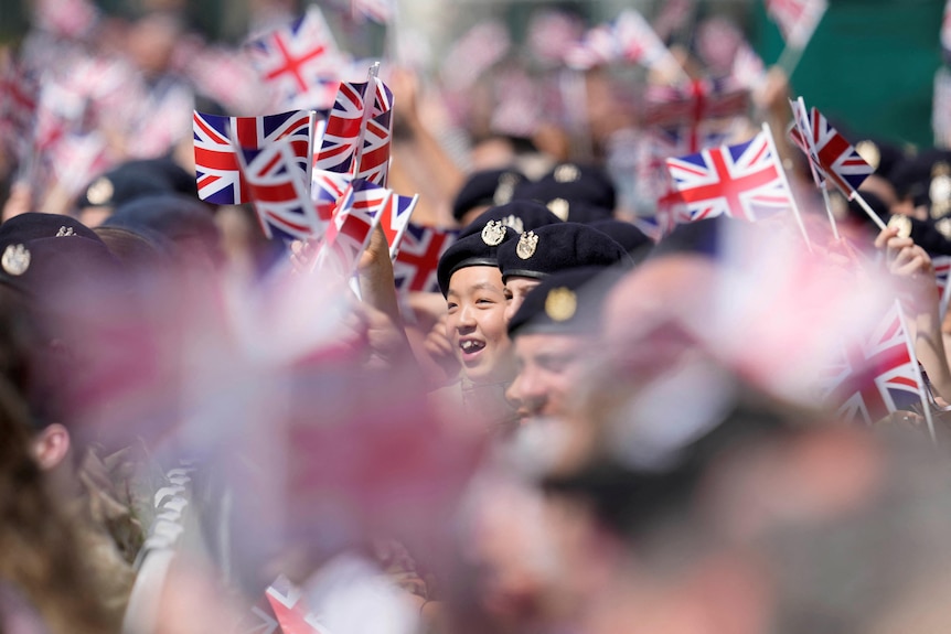 Soldiers in berets wave the Union Jack flag 
