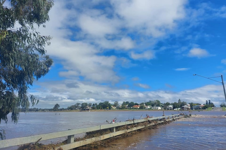 Flooding around Grafton Bridge in Warwick, houses on other side of Condamine River visible with floodwater close to them