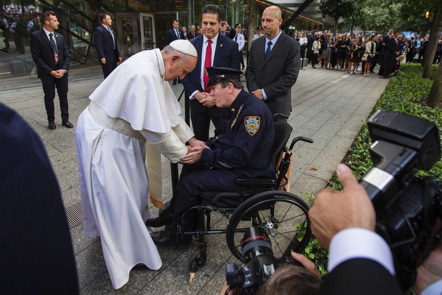 Pope Francis shakes the hand of a New York Police Department officer while visiting the 9/11 Memorial in New York.