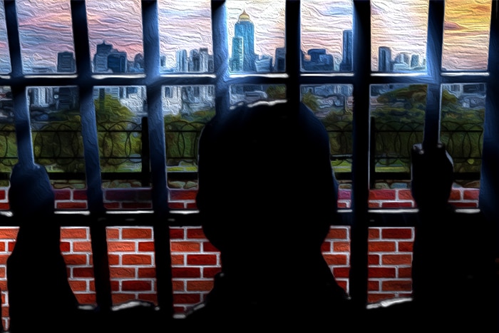 A drawing depicts an inmate holding on to bars and looking at the outside world cityscape.