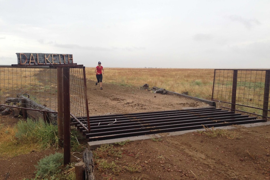 Joy McClymont runs towards the gate of her property, Dalkeith.