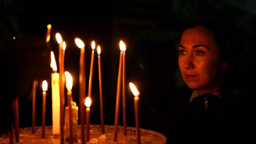 A Christian worshipper lights candles at the Church of the Nativity in Bethlehem