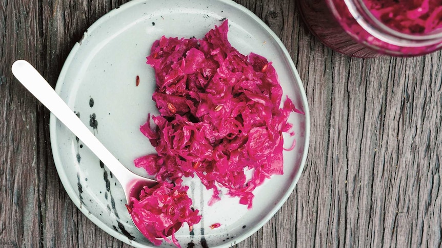 Fermented vivid red cabbage spooned onto a plate.