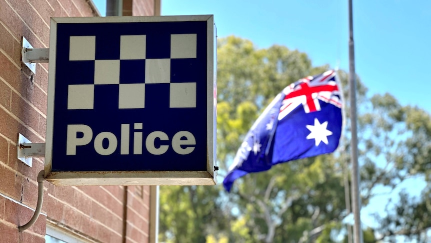 A police sign logo in Bordertown next to an Australian flag at half mast.