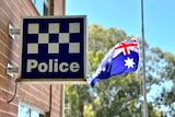 A police sign logo in Bordertown next to an Australian flag at half mast.