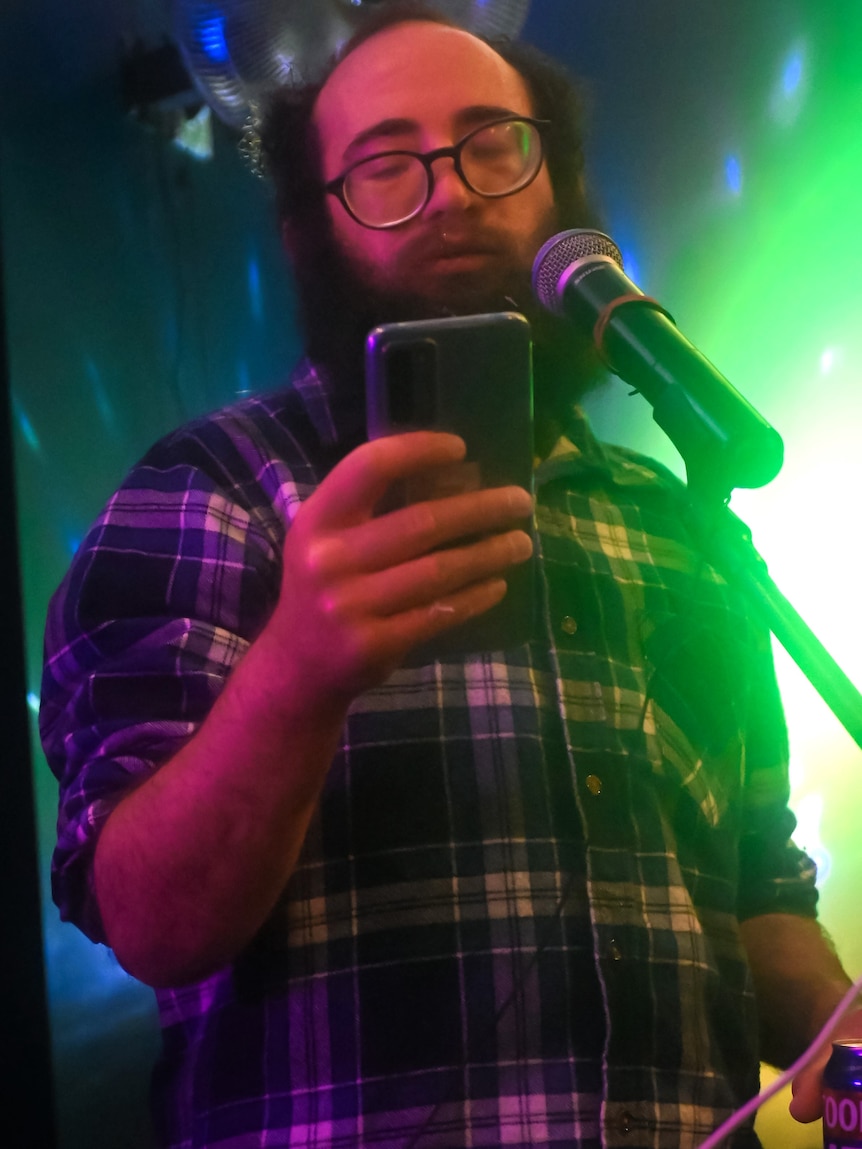 a man speaking at an open mic at a bar.