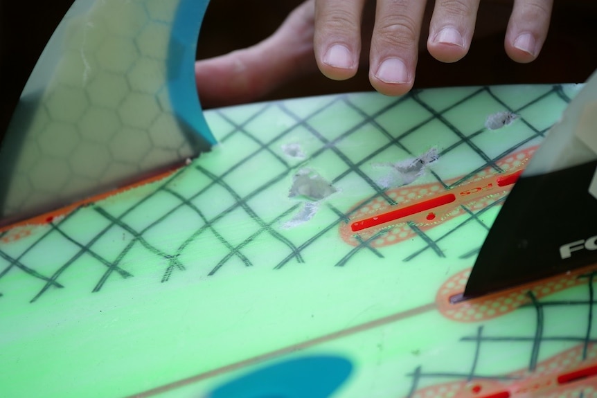 Shark teeth marks in Alex Travaglini's surfboard