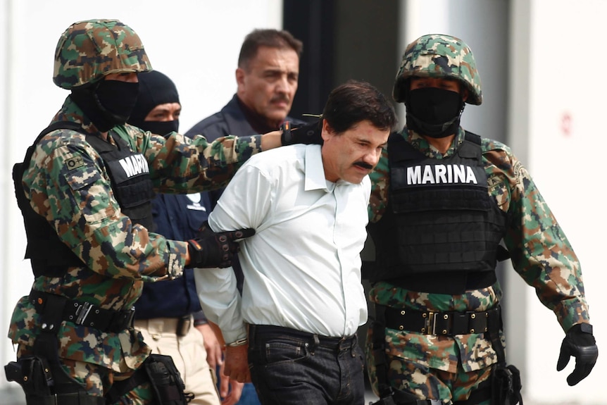 Joaquin Guzman, known as 'Shorty' or 'El Chapo', is escorted by soldiers at the Navy's airstrip in Mexico City.