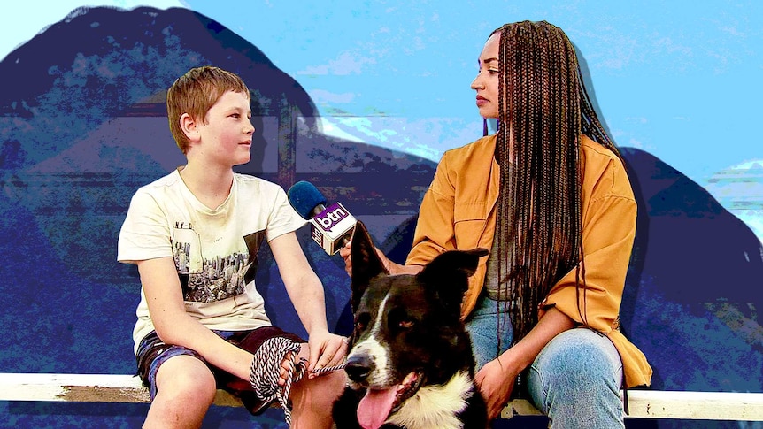 Amelia sits n a bench interviewing boy holding his dog on a leash.
