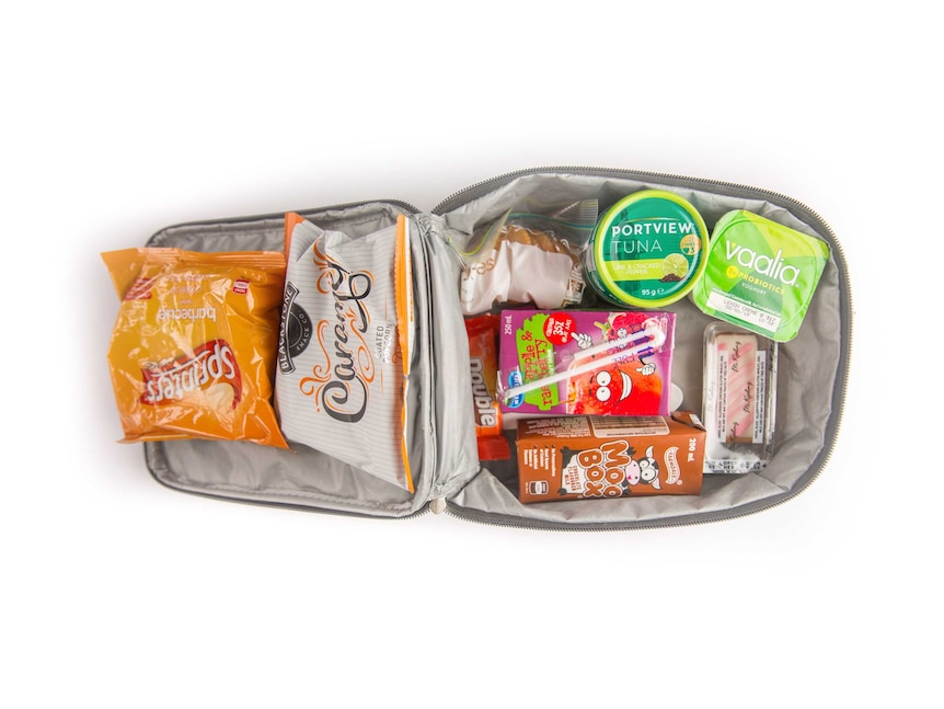 Tuna, crackers, yoghurt, cake, biscuits, potato chips, caramel popcorn and a chocolate flavoured milk box in a cooler bag.