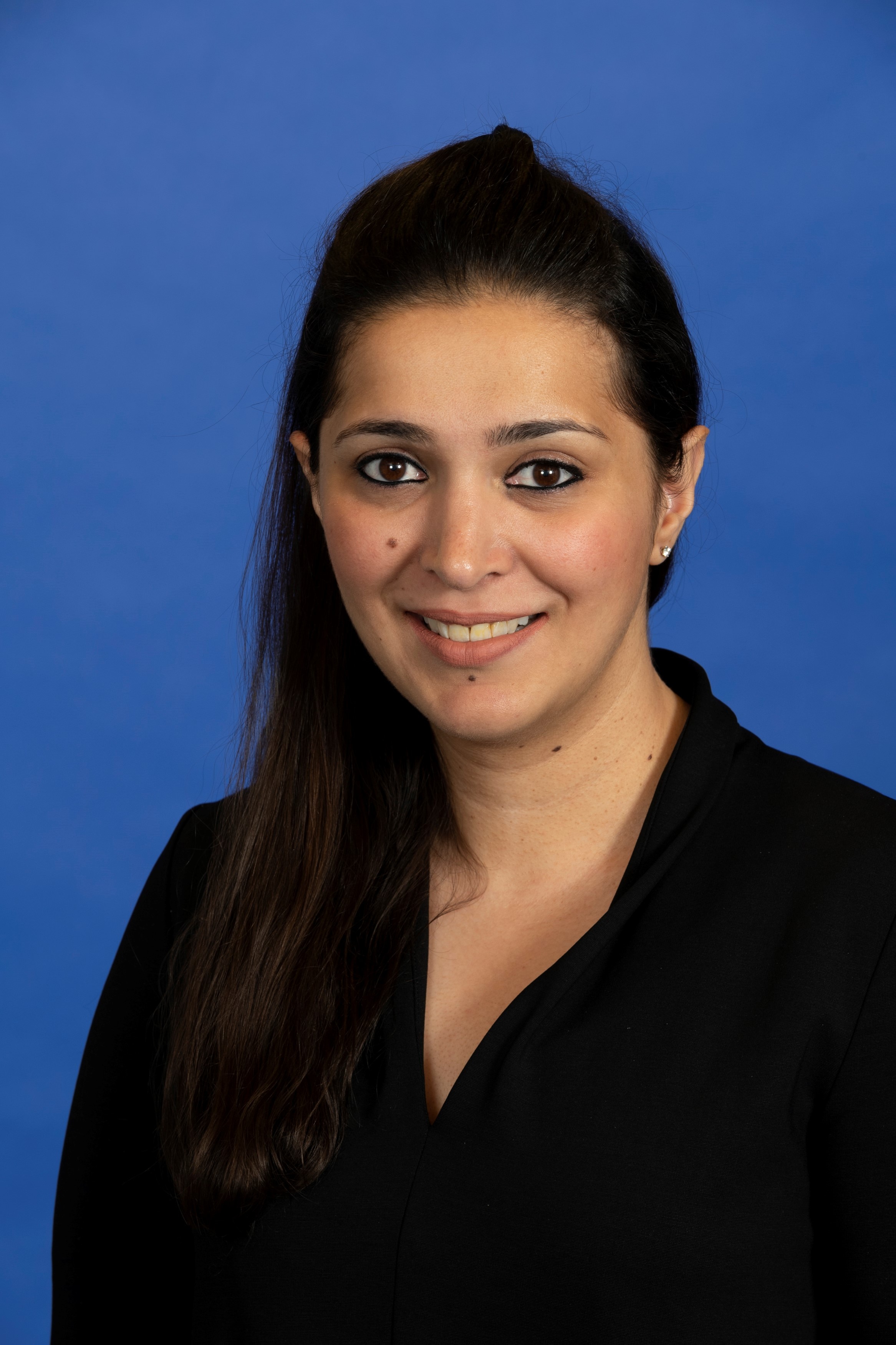 A woman smiling against a blue background
