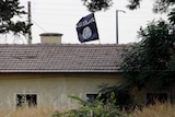 An Islamic State flag flies over the custom office of Syria's Jarablus border gate with the Turkish town of Karkamis