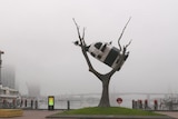 A sculpture surrounded by fog.
