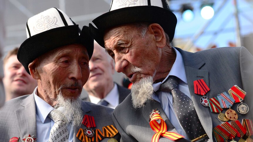 Two elderly men with matching hats, beards and medals