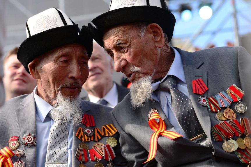 Two elderly men with matching hats, beards and medals