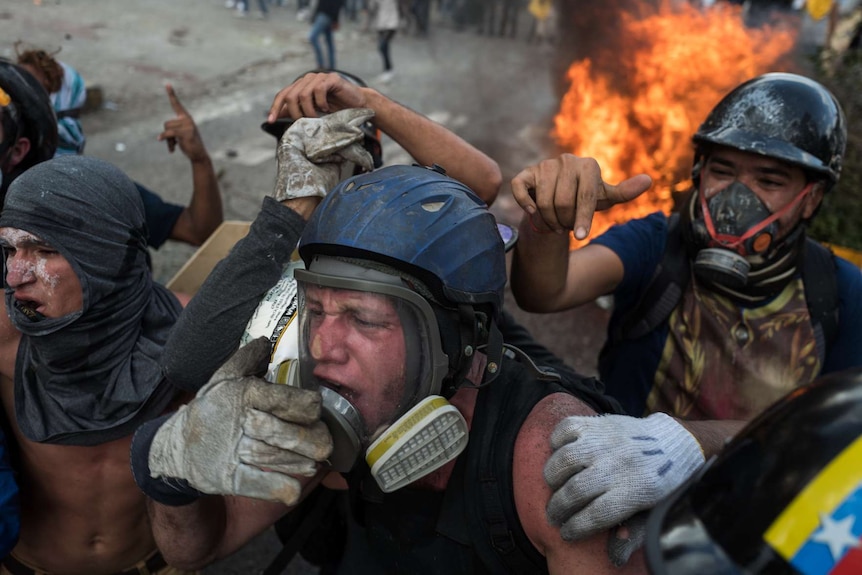 Three men move away from a fire