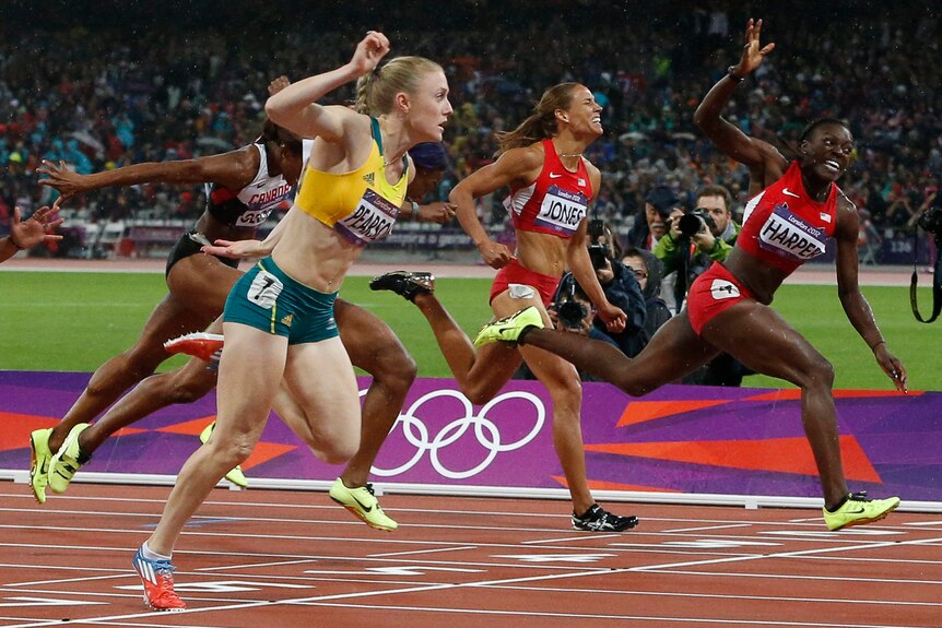 Sally Pearson and Dawn Harper (R) throw themselves at the line in the 100m hurdles final.