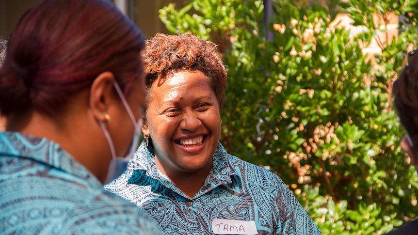 A woman smiles as she talks to colleagues at an aged care facility in WA.