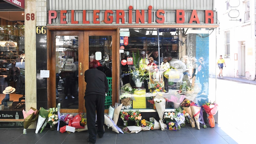 Mourners pay their respects outside of Pellegrini's cafe on Bourke Street, Melbourne.