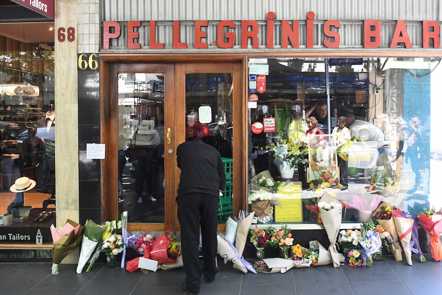 Mourners pay their respects outside of Pellegrini's cafe on Bourke Street, Melbourne.