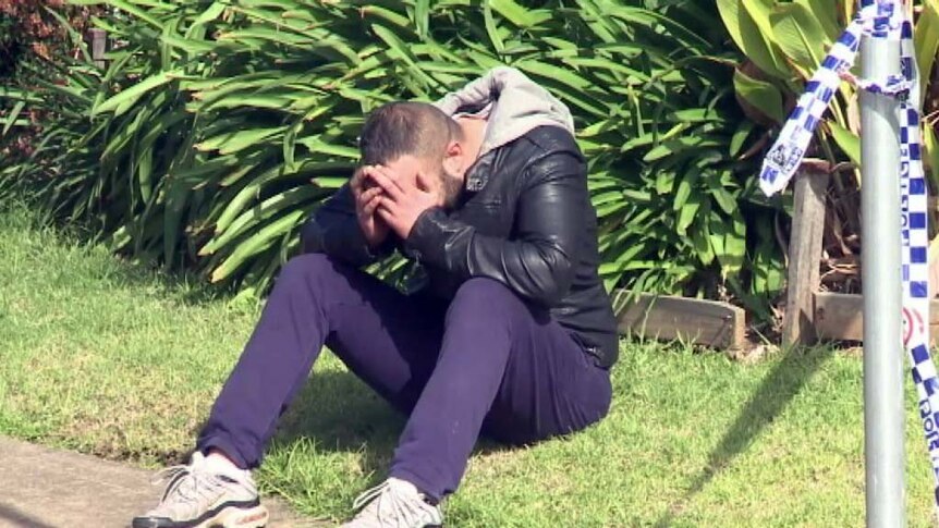 A man mourns after a relative was shot dead in a drive-by shooting