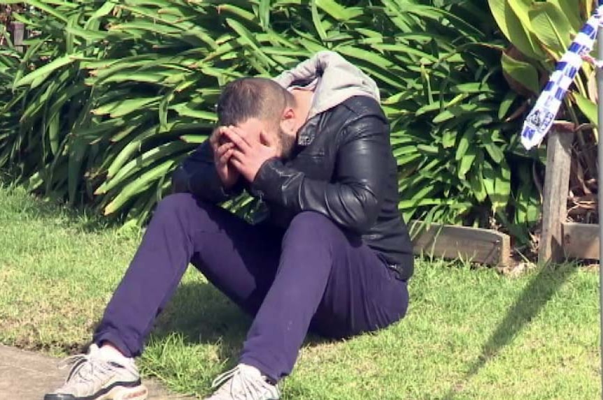 A man mourns after a relative was shot dead in a drive-by shooting