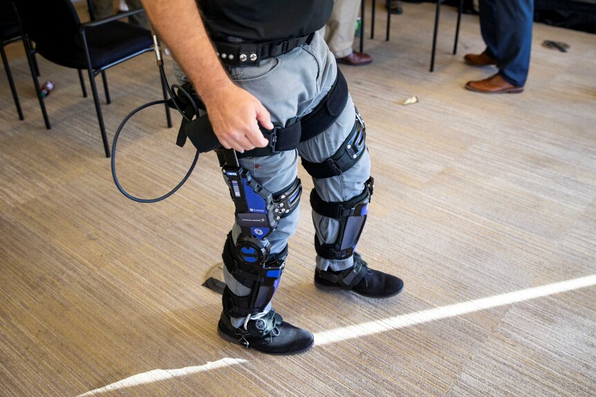 A man wearing a pair of jeans and a set of what appears to be legs braces equipped with technological elements
