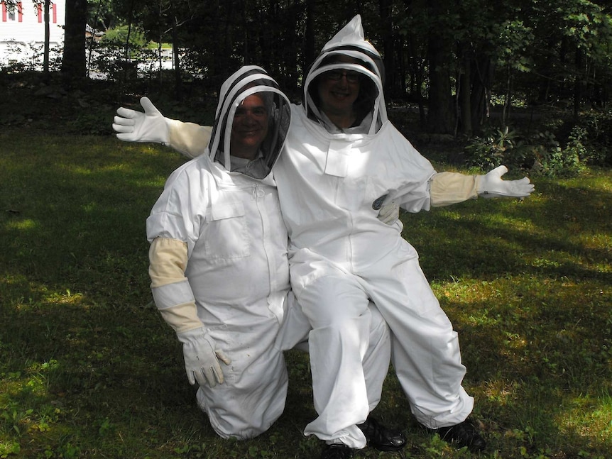 Two people in beekeeping outfits.