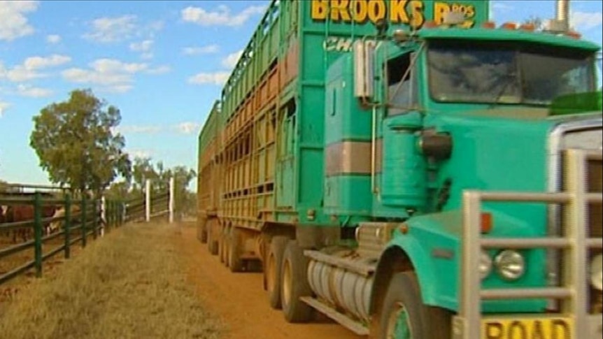 Generic TV still of road train truck driving on dirt Qld road