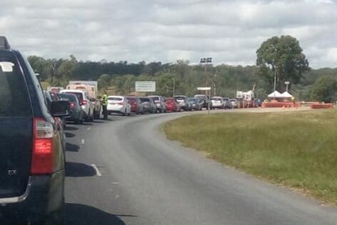 Cars lined up along a road to enter Cherbourg