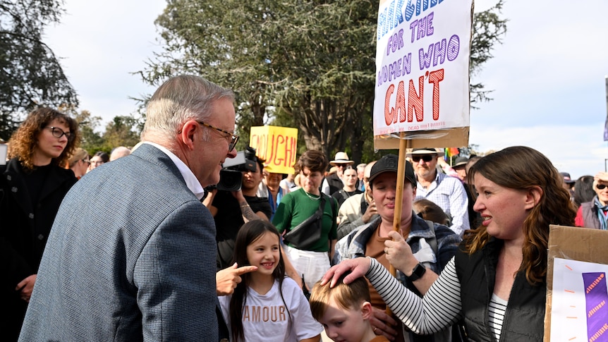 Anthony Albanese speaks with a woman at a rally against gendered violence