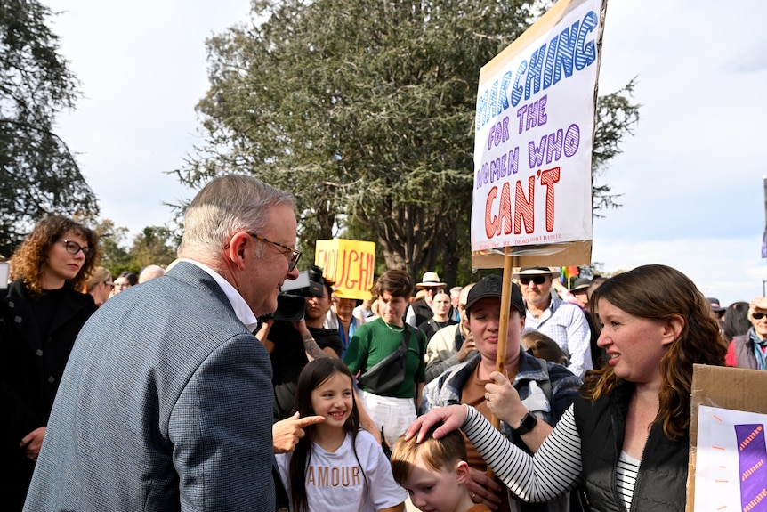 Anthony Albanese speaks with a woman at a rally against gendered violence