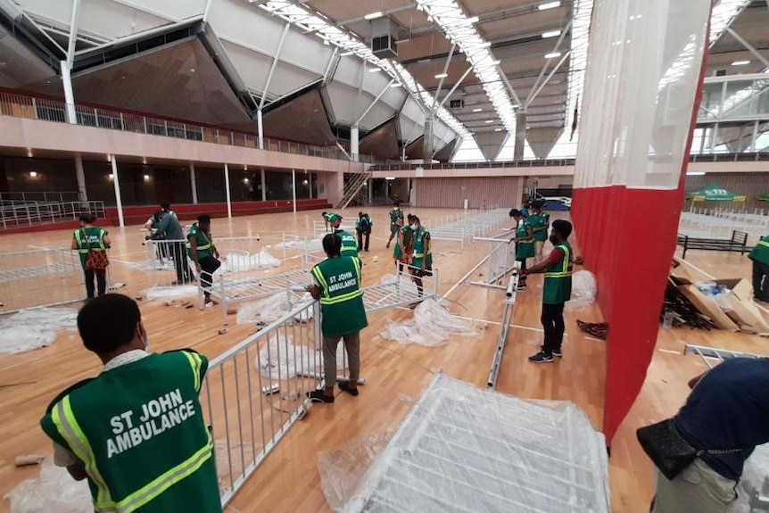 Healthcare workers setting up a temporary field hospital. 