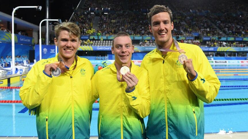 Timothy Hodge, Timothy Diskin and Blake Cochrane smile and hold their Commonwealth Games medals.