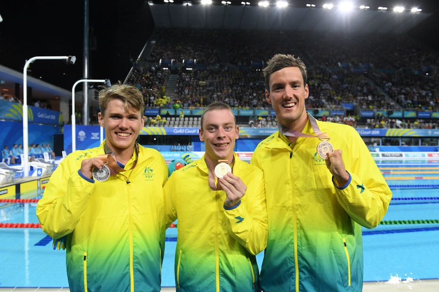 Timothy Hodge, Timothy Diskin and Blake Cochrane smile and hold their Commonwealth Games medals.