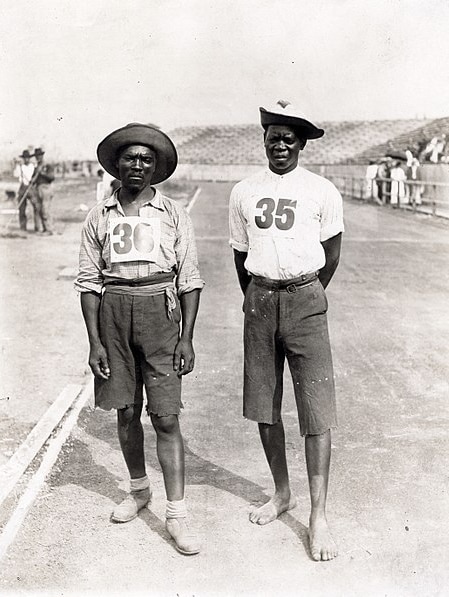 Two African men stand on a running track