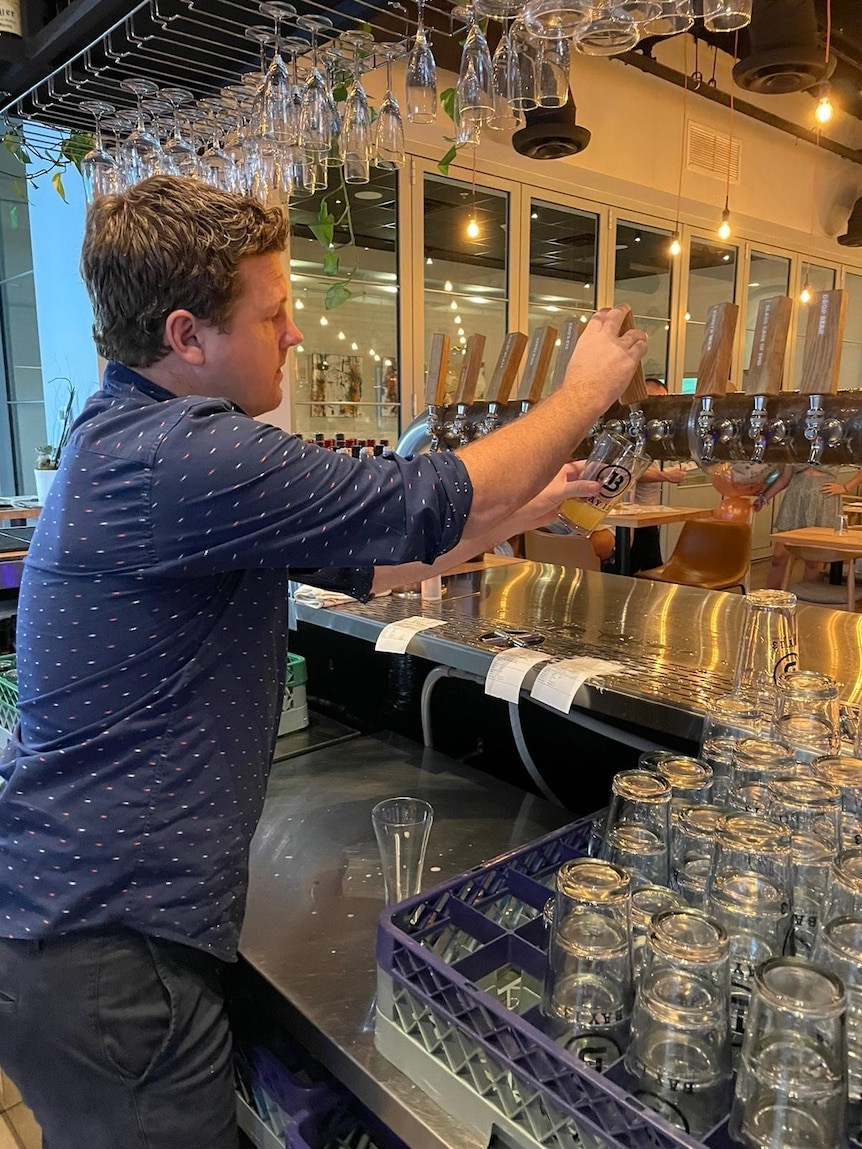 Man pouring a drink at a bar. 