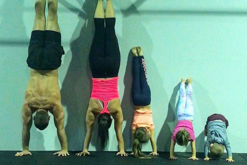 Hannah Clarke and Rowan Baxter with her three children doing handstands at a gym.