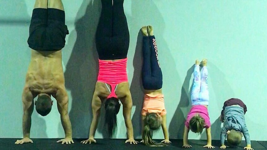 Hannah Clarke and Rowan Baxter with her three children doing handstands at a gym.