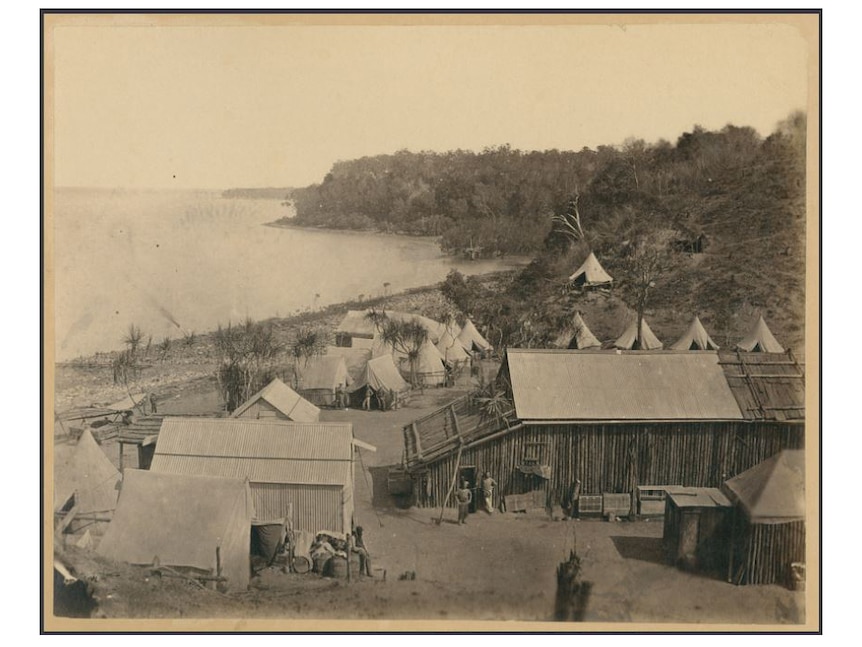 Old photo of Palmerston showing harbour entrance, tents and buildings overlooking the sea.