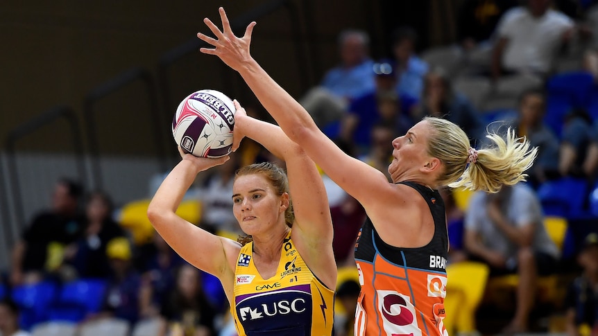 Stephanie Wood looks to pass the ball as April Brandley reaches above her