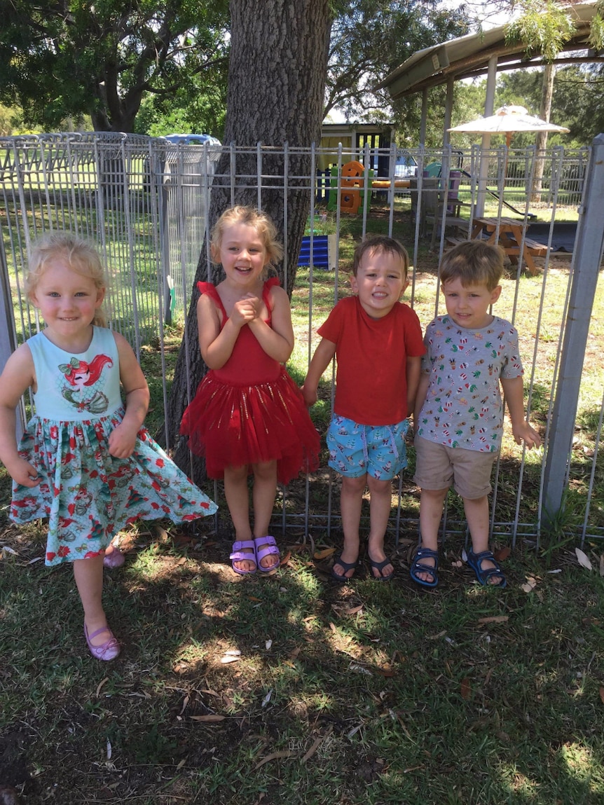 Four children pose for the camera at a playgroup near Newcastle.